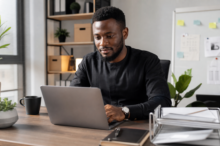 Professional setting showing a business user configuring email for a custom domain on a laptop in a modern office